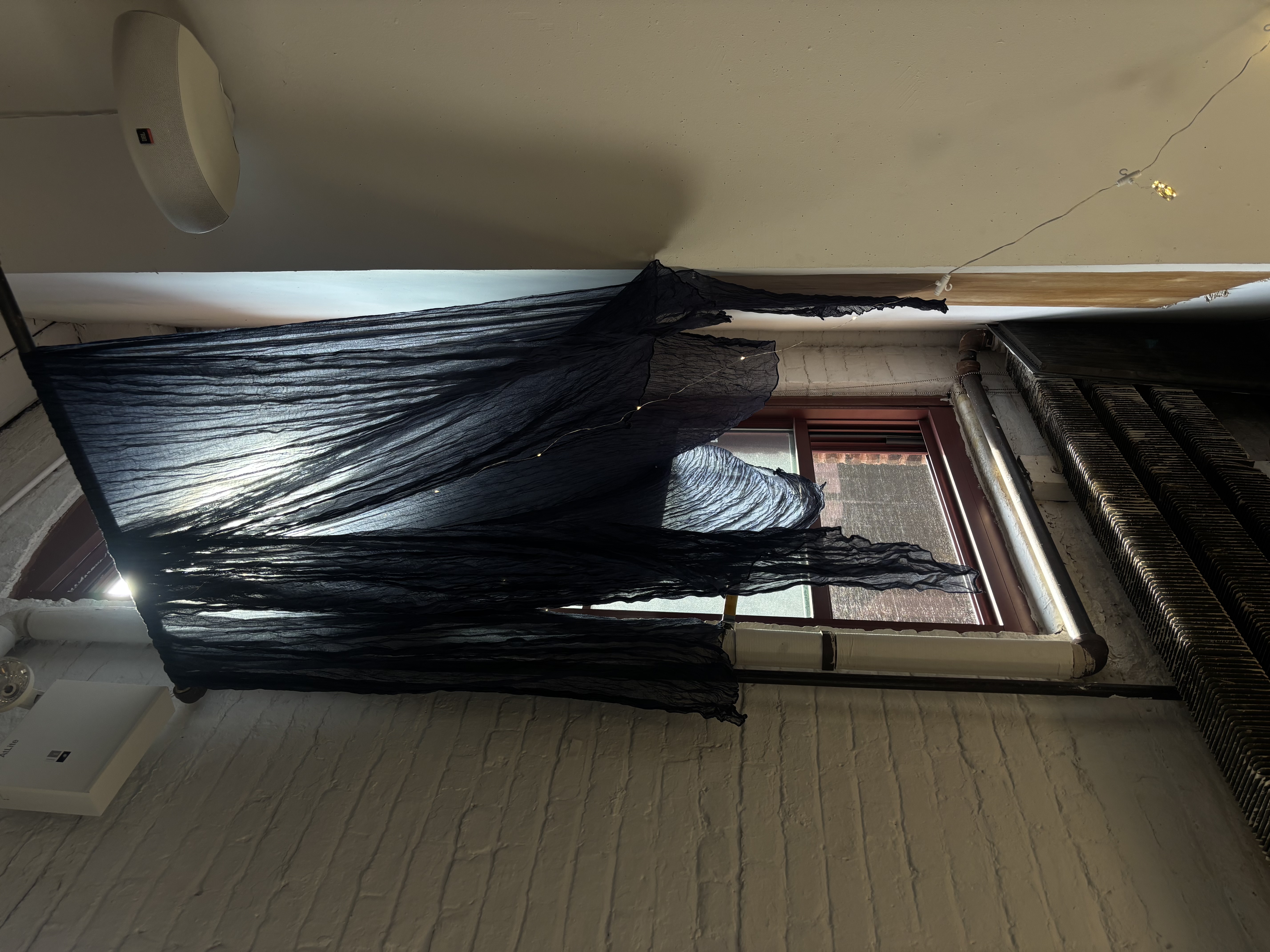 Image shows the first iteration of the installation process showcasing drapes and twinkling lights.